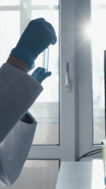 Laboratuvar önlüğü giymiş kendini adamış bir bilim adamı ve PPE araştırmaları için teknoloji ve yenilikçi veri görselleştirme araçlarıyla donatılmış modern bir laboratuvarda örnekleri titizlikle analiz ediyor.