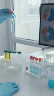 Kendini adamış bir bilim adamı laboratuvarda deneyler yapıyor. Renkli test tüpleriyle uğraşırken karmaşık verileri analiz ediyor. Modern bilimsel araştırmalar ve yenilikler sergiliyor.