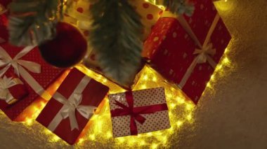 Parlak renklere bürünmüş, parlak ışıklarla çevrili, büyülü bir tatil atmosferi yaratan, güzel düzenlenmiş Noel hediyeleri ve kurdeleler..