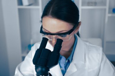 Bir laboratuarda, kendini adamış bir kadın bilim adamı yüksek çözünürlüklü mikroskop altında biyolojik örnekler üzerinde çalışarak yaşam anlayışımızı geliştiren yenilikçi araştırmalara katkıda bulunur.