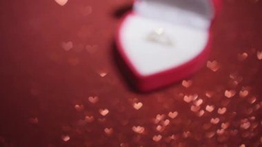 Kalp şeklinde bir kutunun içindeki çarpıcı bir yüzük, Sevgililer Günü 'nün büyüleyici özünü yakalar ve çiftler arasındaki derin romantik aşkı ve içten bağı sembolize eder.