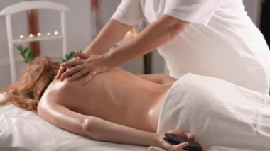 Sakin bir kaplıcada, yetenekli bir terapist sakin bir müşteriye rahatlatıcı bir masaj yapar. Dekor ve ortam aydınlatmasının ortasında, dinlenmek ve gençleşmek için sakin bir atmosfer sağlar.
