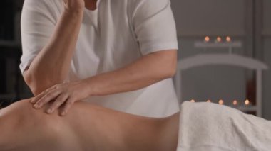 Tecrübeli bir masaj terapisti, sakin bir kaplıcada, rahatlatıcı bir ortam yaratarak rahatlatıcı bir sırt masajı sağlar.