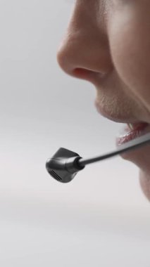 Kulaklığını kullanan odaklanmış bir çağrı merkezi operatörünün yan profili. Sohbete derinden dalmış, yumuşak odaklı bir geçmişi var. Konsantrasyonu ve profesyonelliğini vurguluyor.