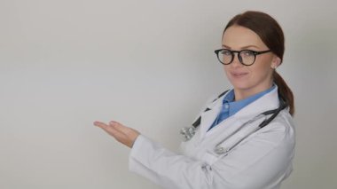 Beyaz önlüklü ve şık gözlüklü kendini adamış bir sağlık uzmanı açık bir alana doğru hareketlenerek mevcut herkese sıcak ve bilgilendirici bir atmosfer yaratıyor.