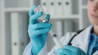 Biyoloji merkezindeki bir laboratuar asistanı örnekleri test ve moleküler analiz için dikkatlice hazırlıyor. Koruyucu eldiven giyen bir kadın elinde kimyasal matara tutuyor. Yüksek
