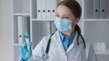 Cerrahi maske takan ve beyaz önlük giyen çalışkan bir sağlık uzmanı, düzenli bir şekilde hasta detaylarını gözden geçiriyor. Tıbbi belgeler ve çizelgeler ile dolu bir ofiste.