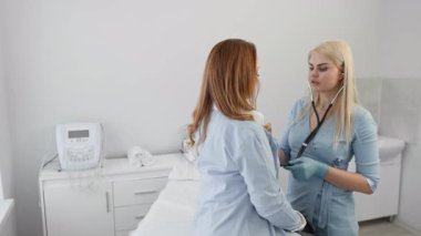 Parlak ve misafirperver bir klinikte, nitelikli bir tıp uzmanı, çeşitli sağlık sorunları ve ihtiyaçlarını etkili bir şekilde ele almak ve tartışmak için bir hastayla kapsamlı bir istişarede bulunur.