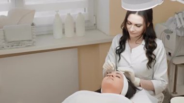 Deneyimli bir kozmetolog huzurlu bir klinikte cilt bakımını gençleştirir, çeşitli kozmetik prosedürleri ve optimum cilt sağlığı için gelişmiş cilt bakımı tekniklerini vurgular.