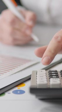 Becerikli bir profesyonel inceleme finansal belgeler, kavrayışlı notlar alıyor ve etkili yönetim için titiz ve kapsamlı bir analiz gerektiren ayrıntılı bir muhasebe süreci sergiliyor