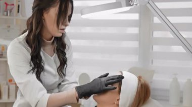 Sakin bir klinik ortamda, yetenekli bir kozmetik uzmanı kırışıklıkları azaltmak ve daha genç görünmek için hastaların yüz gençleşmesini arttırmak için botulinyum enjeksiyonları yapar.