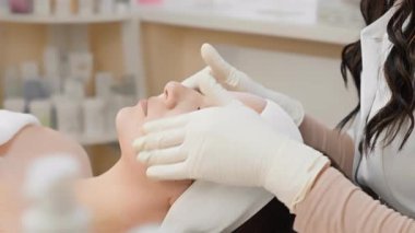 Yetenekli bir kozmetikçi, son teknoloji ve tekniklerle modern bir klinikte rahatlatıcı bir atmosfer yaratarak cildini gençleştirmek için ileri bir yüz tedavisi uyguluyor.
