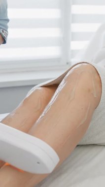 Rahatlamaya odaklanmış sakin, iyi aydınlatılmış bir klinikte, hasta sertifikalı bir kozmetologdan lazer tüy çıkarma prosedürü alır, tedavi sırasında güvenlik ve konfor sağlanır.