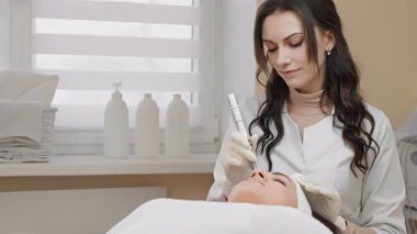Modern bir klinikte, yetenekli bir kozmetikçi yenilikçi teknikler ve ekipmanlar kullanarak gelişmiş bir cilt bakımı uygularken, aynı zamanda rahatlatıcı bir rahatlama ortamı sağlar.