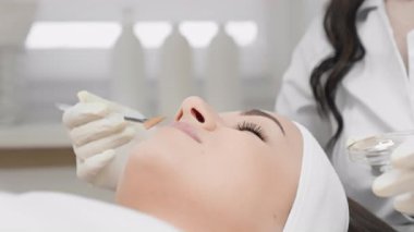 Deneyimli bir kozmetikçi, parlak bir klinikte cilt bakımı için rahatlatıcı bir prosedür sunarak, müşterilerin yüksek kalitede cilt bakımı ile tatmin olmalarını sağlar.