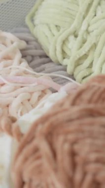 Çeşitli renklerde yumuşak ipliklerin canlı bir karışımı, bir depolama kutusunda düzenli, eşsiz dokular ve güzel renkler sergileniyor, el yapımı, örgü ve DIY projeleri için ideal.