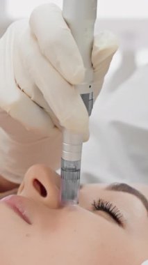 Yetenekli bir kozmetolog, bir hastanın yüzünde mikro tedavi uygular, cildini gençleştirmeye ve huzurlu bir klinik ortamında görünümü geliştirmeye odaklanır.