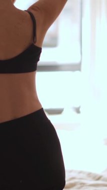 Parlak, güneşli bir yatak odasında, genç bir insan sevinçle esneyerek, bencillik yolculuğunu ve kendileri olma özgürlüğünü sembolize eden bir an kucaklıyor.