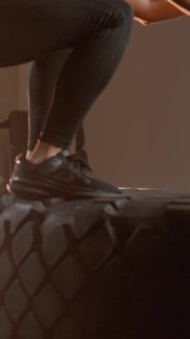 Bir atlet, modern bir spor salonu ortamında hem güç hem de çeviklik sergileyerek etkileyici tekerlek atlamaları sergiliyor. Formda ve işlevsel eğitim rutinlerinde kararlılığını vurguluyor.