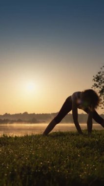 Şafakta, genç bir kadın sisli sularda yoga yapıyor, güneş ışığını kucaklıyor ve iç huzuru ve farkındalığı somutlaştırıyor. Hareketleri doğada sükunet ve ahenk yaratır.