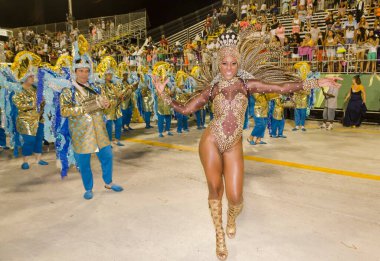 Santos City, Brezilya 'daki karnaval. Davul kraliçesi müzisyenlerin önünde dans ediyor. Vila Mathias samba okulunun geçit töreni. 3 Mart 2014. 