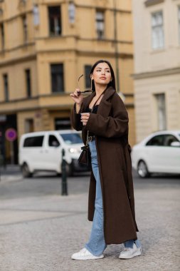 Prag 'da elinde güneş gözlüğü ve kağıt bardak tutan genç bir kadın. 