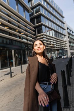 Paltolu moda turist Prag sokaklarında güneş ışığında duruyor. 