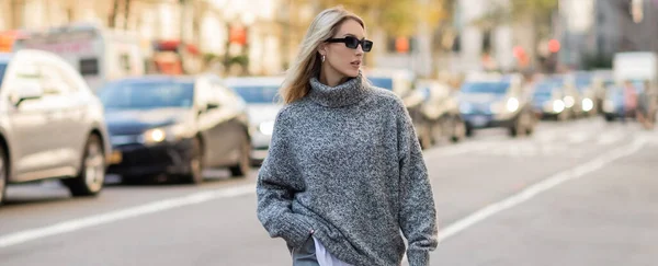 stock image blonde woman in sunglasses and trendy outfit walking on street of New York city, banner