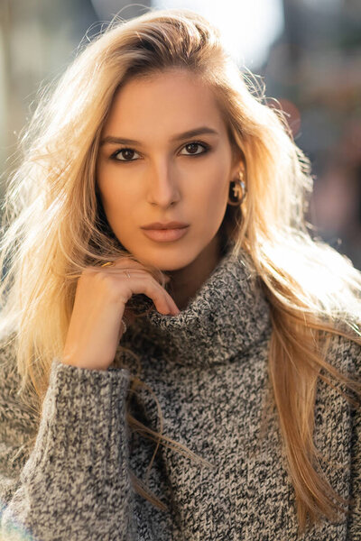 portrait of pretty young woman in sweater looking at camera in New York city 