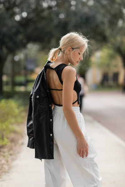 Widok Boku Blondynka Kobieta Biały Ładunek Spodnie Stojące Czarny Skórzana — Zdjęcie stockowe