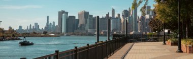 Manhattan gökdelenleri olan şehir manzarası ve New York 'ta Hudson nehrinin yanında yürüme yolu olan dolgu.