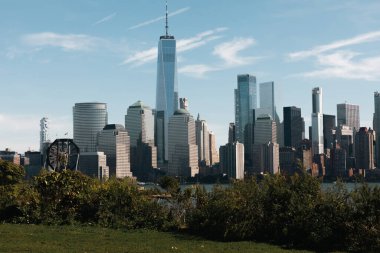 financial center of Manhattan with One World Trade Center near Hudson river and park in New York City clipart
