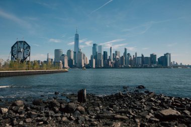 Hudson nehri ve New York 'taki modern Manhattan gökdelenleriyle manzaralı bir şehir.
