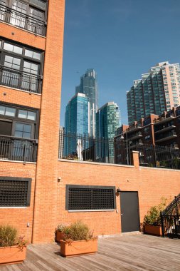 potted plants on terrace of brick building with scenic view of New York City skyscrapers