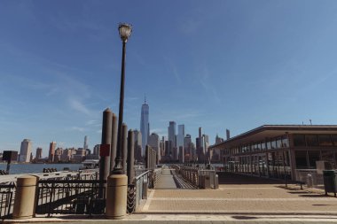 port and embankment with walkway and cityscape of modern skyscrapers in New York city