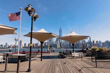 NEW YORK, USA - OCTOBER 13, 2022: embankment of Hudson river and cityscape of Manhattan skyscrapers under blue sky