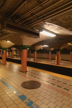 platforms of New York subway with columns and lamps clipart