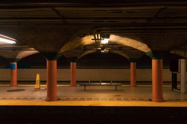 subway station with columns and bench in New York City clipart