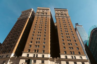 New York 'taki Tudor City apartmanının alçak açılı görüntüsü mavi gökyüzüne karşı.