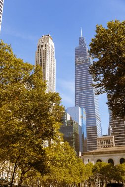 Rockefeller Plaza ve Central Park kuleleri New York 'ta şehir sokağındaki sonbahar ağaçları yakınında.