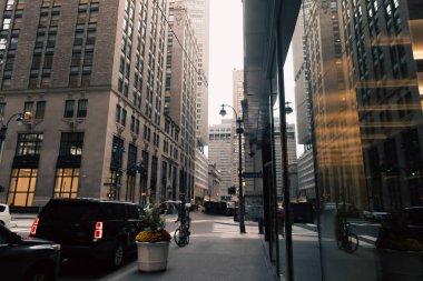 car road and sidewalk between modern buildings of urban street in New York City clipart