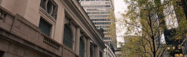New York caddesinde sonbahar yapraklı ağaçların yanındaki gri taş bina, afiş.