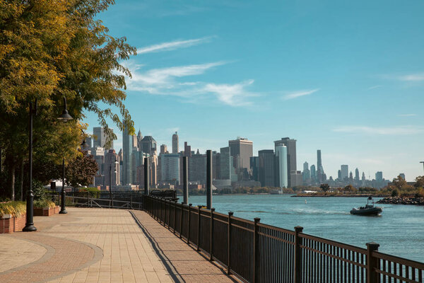 scenic view of Manhattan skyscrapers from embankment of Hudson river in New York City