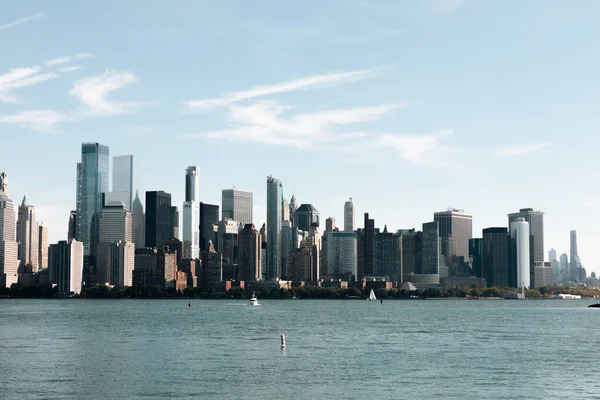 Hudson nehri körfezi ve New York 'ta mavi gökyüzü altında modern Manhattan gökdelenleri.