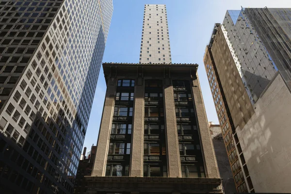 Rockefeller Merkezi 'nin alçak açılı görüntüsü ve New York şehir merkezindeki taş bina.