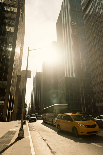 НЬЮ-ЙОРК, США - 13 октября 2022 года: дорожное движение и современные здания в солнечный свет на городской улице