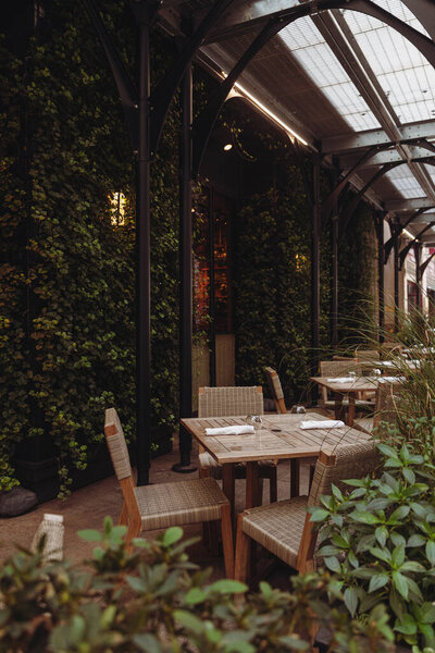 кафе терраса под прозрачной крышей рядом со зданием, покрытым зеленым плющом в Нью-Йорке