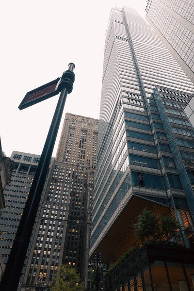 низкоугольный вид дорожного столба с указателем около небоскребов в центре Манхэттена в Нью-Йорке
