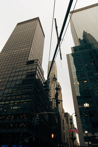 low angle view of electric wires and contemporary buildings with glass facades in New York City