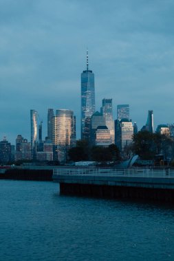 Manhattan gökdelenleri ve Hudson nehri üzerindeki iskele alacakaranlıkta manzaralı şehir manzarası